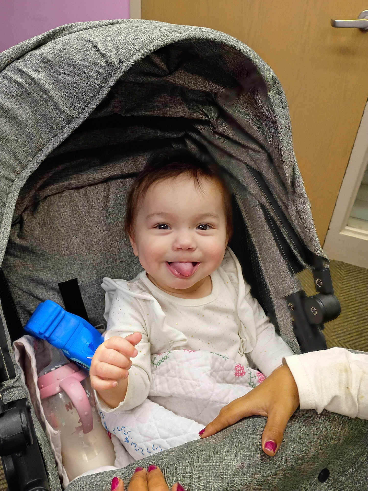 Eyliia joined the competition — help win amazing prizes! baby, infant, stroller, smiling, tongue_out, baby_bottle, blanket, hand, nail_polish, canopy, hood, indoors, portrait, cute, happy, toy, seat, clothing, door, carpet