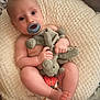 baby, infant, pacifier, stuffed_animal, blanket, soft_texture, cute, child, lying_down, bare_skin, toy, indoors, cozy, toddler, sleeping_area, comfort, small_hands, small_feet, head, face