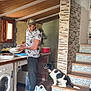 Bobo is registered to the contest to win money with this photo: appliance, bucket, cap, casual_clothing, dog, home, indoor, kitchen, man, pet, red_collar, stairs, stone_wall, tiled_floor, tiled_stairs, washing_dishes, washing_machine, water_bottle, window, wooden_ceiling