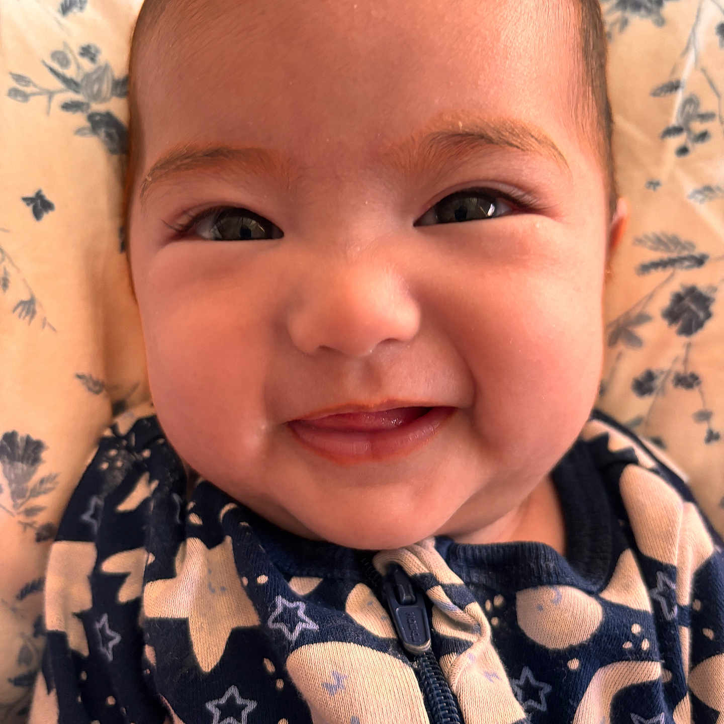 Ellie Victoria joined the competition — help win amazing prizes! baby, blanket, blue_clothing, cheeks, child, closeup, cute, eyes, face, floral_pattern, happy, infant, lying_down, moon, mouth, onesie, portrait, skin, smiling, stars
