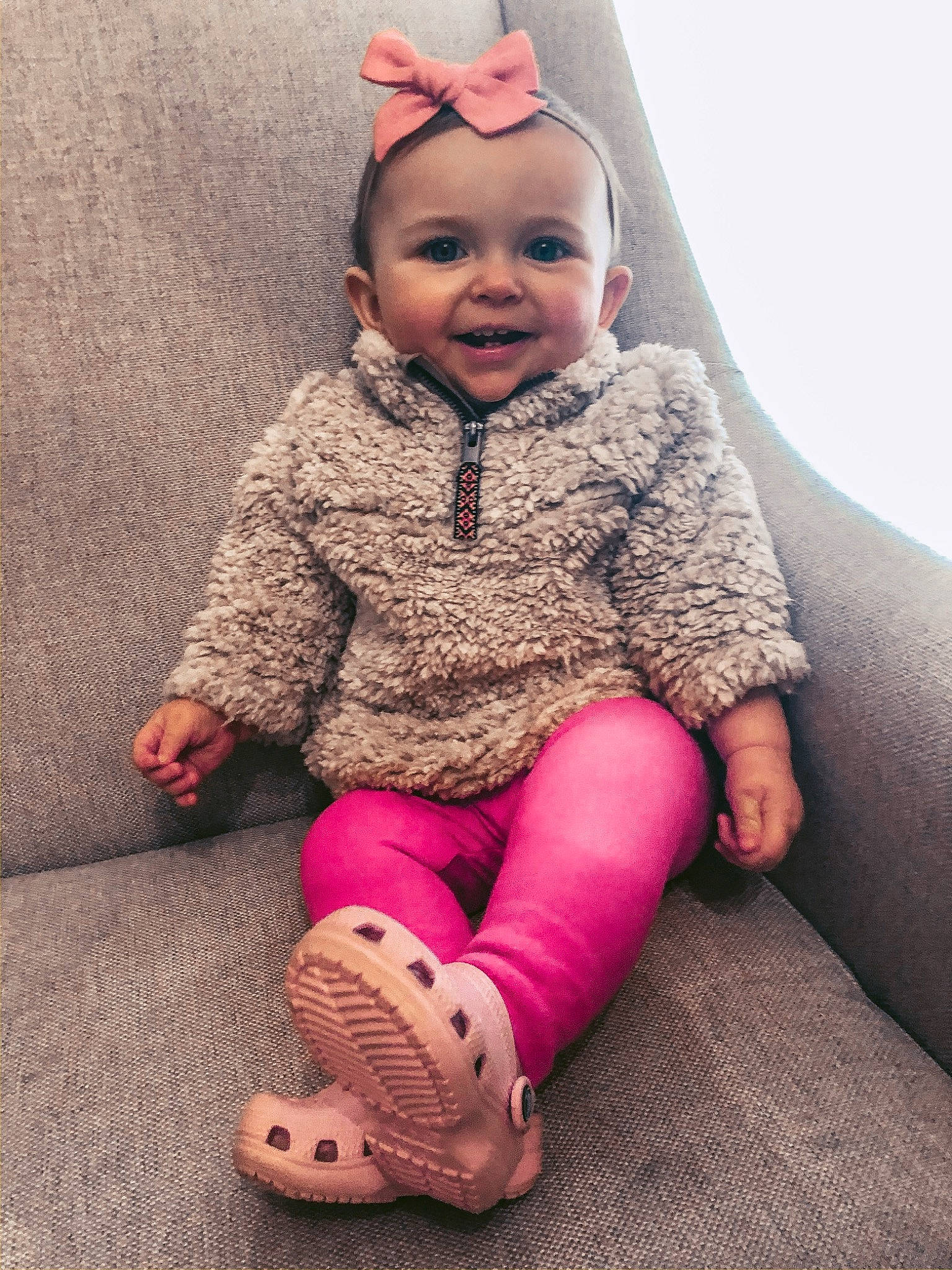 Roxie is registered to the contest to win money with this photo: baby, child, child_model, ear, face, flooring, footwear, fun, head, leg, nose, outerwear, people, person, pink, sitting, skin, sleeve, smile, tights