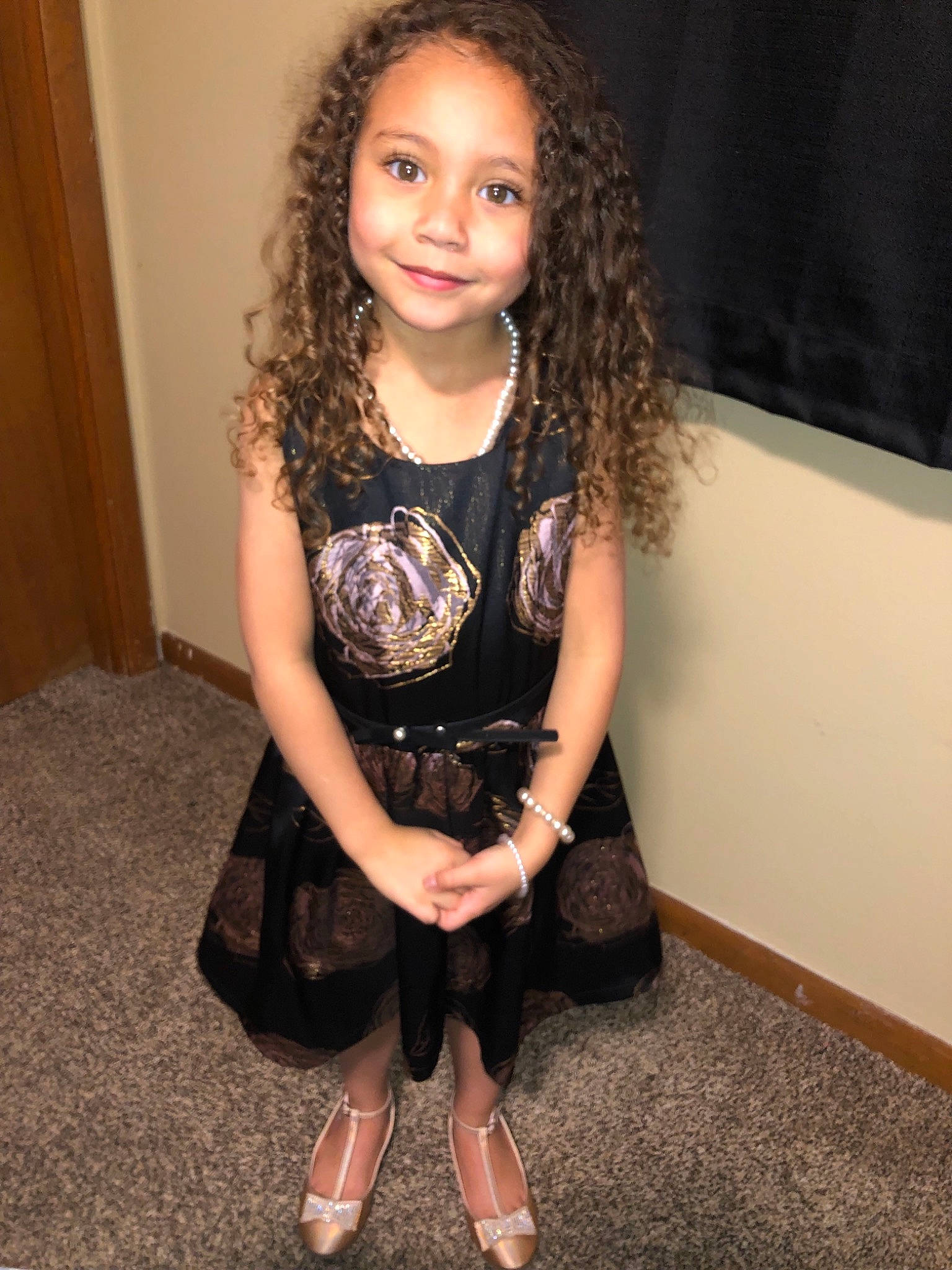 Mia Isabella  is registered to the contest to win money with this photo: brown_hair, child_model, flooring, girl, hairstyle, joy, leg, little_black_dress, long_hair, pattern, person, shoulder, smile, tights