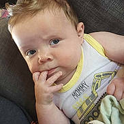 Isiah joined the competition — help win amazing prizes! baby, infant, child, face, hand, fingers, blue_eyes, light_hair, tank_top, sitting, couch, blanket, clothing, expression, indoors, comfort, cute, portrait, young, person