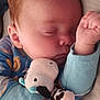 baby, sleeping, plush_toy, cow, pajamas, blue_clothing, infant, hand, closed_eyes, cuddle, soft_toy, resting, peaceful, cute, child, bedtime, comfort, skin, face, fingers
