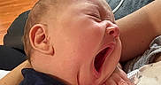 Luka is registered to the contest to win money with this photo: arms, baby, blanket, closeup, clothing, cozy, face, floor, furniture, hand, head, home, indoor, infant, person, relaxing, skin, sleepy, wooden_floor, yawning