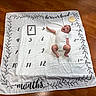 Luka joined the competition — help win amazing prizes! baby, infant, milestone_blanket, wooden_floor, white_onesie, months, numbers, frame, celebration, smiling, lying_down, cute, child, floor, blanket, home, indoor, small, adorable, portrait