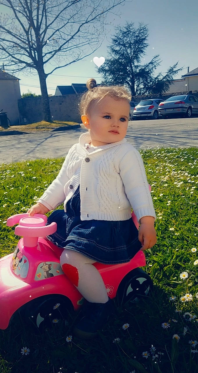 Marylou participe au concours pour gagner de l'argent avec cette photo : automotive_tire, baby, cool, fender, grass, happy, light, motor_vehicle, person, pink, plant, riding_toy, shoe, sky, tire, toddler, toy, tree, vehicle, wheel