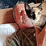 Maya a rejoint le concours — aidez-le/la à gagner de superbes lots ! man, kitten, cat, bed, indoor, portrait, animal, pet, holding, feline, whiskers, calico, casual, resting, adult, facial_hair, wooden_headboard, pillow, shirt, curious