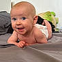 baby, smiling, tummy, bed, diaper, blue_eyes, happy, infant, skin, head, person, young_child, indoors, pillow, blanket, cute, child, expression, face, lying_down