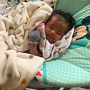 Zoie is registered to the contest to win money with this photo: baby, baby_rocker, blanket, carpet, child, clothing, comfort, cute, face, indoors, infant, mickey_mouse, peaceful, polka_dots, resting, sleeping, smile, soft, striped_glove, toddler