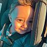 toddler, child, car_seat, sunlight, smile, hair, seatbelt, blue_clothing, portrait, indoors, baby, safety_harness, cute, face, happy, young_child, warm_light, car_interior, child_safety, casual