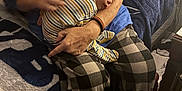 Oliver joined the competition — help win amazing prizes! adult, arm, baby, blanket, blue_shirt, checkered_pants, comfort, couch, cozy, hand, home, indoor, person, pillow, pumpkin_pattern, relaxation, resting, sleeping, striped_clothing, warm_lighting