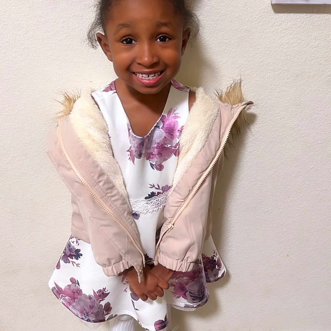 Nikole is registered to the contest to win money with this photo: bodypart, child, clothing, coat, face, female, finger, footwear, girl, happy, head, longsleeve, person, photography, portrait, shoe, sitting, sleeve, smile, sneaker