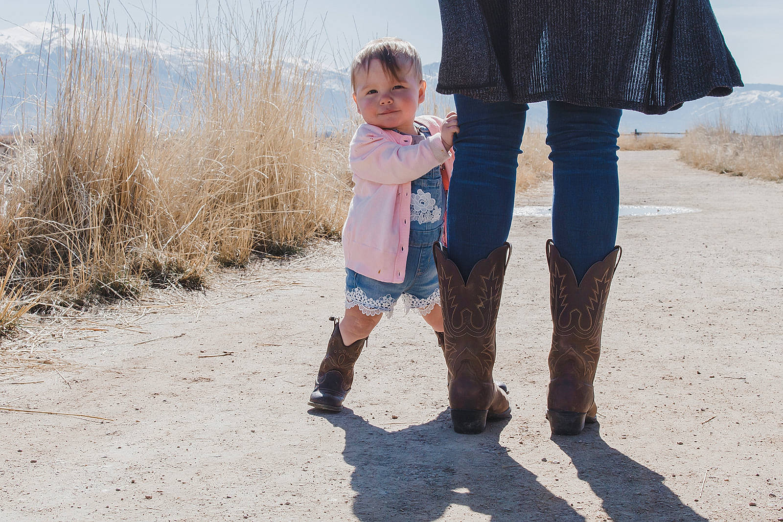 Alyvia is registered to the contest to win money with this photo: child, denim, fun, gesture, grass, happy, holding_hands, human_leg, interaction, landscape, leg, leisure, people_in_nature, person, sand, shoe, shore, sky, sneakers, t_shirt