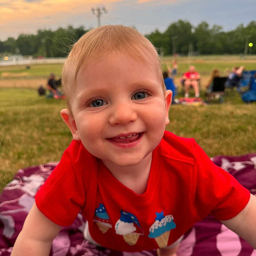 Sawyer joined the competition — help win amazing prizes! baby, bodypart, clothing, dress, face, finger, grass, happy, head, nature, outdoors, park, person, photography, plant, portrait, sitting, smile, summer, t_shirt
