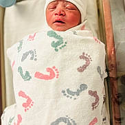 Sri Thanvik is registered to the contest to win money with this photo: newborn, baby, infant, blanket, hospital, bassinet, cap, crying, face, sleeping, wrapped, footprints, child, cute, swaddled, resting, newborn_baby, healthcare, person, toddler