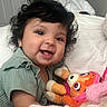 baby, bed, blanket, child, clothing, comfort, cozy, curly_hair, cute, face, happy, indoor, infant, person, plush_toy, portrait, smiling, soft, toy, young_child