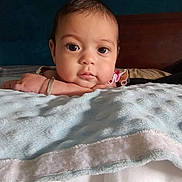 Skylie is registered to the contest to win money with this photo: baby, bedroom, blanket, calm, child, closeup, cozy, curious, cute, expression, face, hand, head, indoors, infant, portrait, resting, skin, soft, young