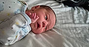 Edward is registered to the contest to win money with this photo: baby, bed, bedroom, blanket, child, eyes, face, hand, indoors, infant, lying_down, newborn, onesie, open_mouth, portrait, sleepwear, soft_lighting, stars, surprised, swaddle