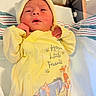 Edward is registered to the contest to win money with this photo: baby, bassinet, birth_announcement, blanket, cartoon_print, child, eyes_open, face, hands, hat, hospital, indoors, infant, lying_down, medical_setting, newborn, onesie, portrait, striped_blanket, yellow_clothing