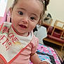 Shaniyah Avangelina joined the competition — help win amazing prizes! toddler, child, baby, indoors, pigtails, bib, pink_clothing, quilt, face, smiling, hand, furniture, chair, portrait, cute, expression, person, young_child, home, colorful