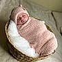 baby, basket, blanket, cozy, cute, face, hat, infant, indoors, laying, pink, portrait, resting, sleepy, soft, swaddled, toddler, warm, woven, young_child