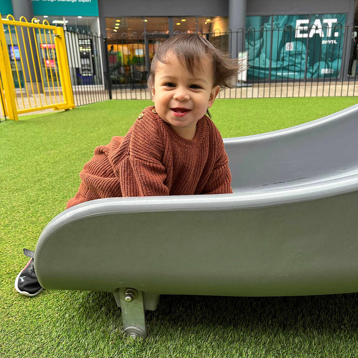 Idris is registered to the contest to win money with this photo: architecture, bodypart, boy, building, child, clothing, face, finger, grass, hand, happy, head, knitwear, lawn, longsleeve, male, nature, outdoorplayarea, outdoors, park