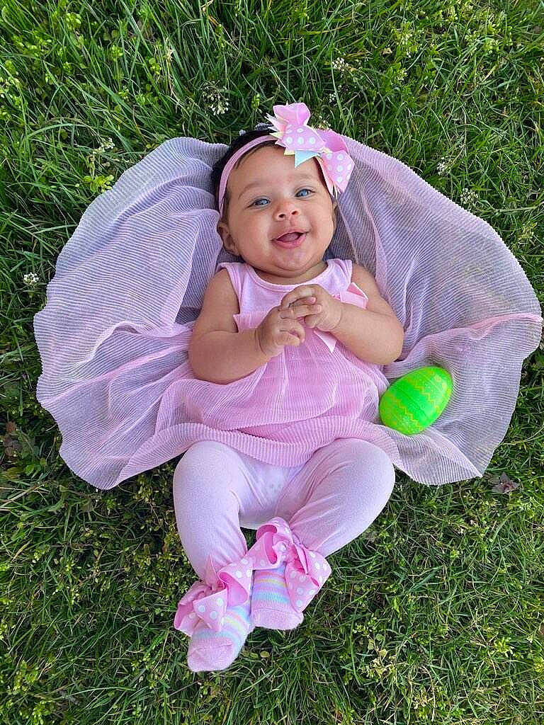 Payton joined the competition — help win amazing prizes! baby, baby_products, baby_toddler_clothing, dress, fashion_accessory, foot, grass, happy, hat, headwear, lawn, magenta, people_in_nature, person, petal, pink, plant, recreation, sitting, smile