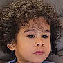 Joab participe au concours pour gagner de l'argent avec cette photo : child, curly_hair, blue_sweatshirt, couch, indoor, portrait, face, young, person, casual_clothing, relaxed, seated, expression, looking_away, skin, head_and_shoulders, home, comfortable, young_child, cozy