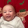 Tjay is registered to the contest to win money with this photo: baby, child, closeup, cute, face, festive, happy, holiday_theme, indoors, infant, plush, portrait, red_background, reindeer, smile, soft_light, striped, tongue_out, white_clothing, young