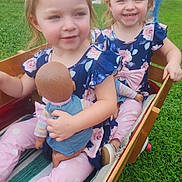Dani And Peyton is registered to the contest to win money with this photo: child, toddler, girl, doll, wagon, outdoor, grass, smiling, happy, matching_clothes, ponytails, play, toy, wooden_wagon, casual, daylight, family, cute, childhood, fun