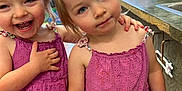 Dani And Peyton is registered to the contest to win money with this photo: child, toddler, girl, matching_dresses, purple_dress, smiling, laughing, indoor, classroom, playful, hair_tied, cute, happy, friends, person, people, two_children, young, preschool, colorful_background