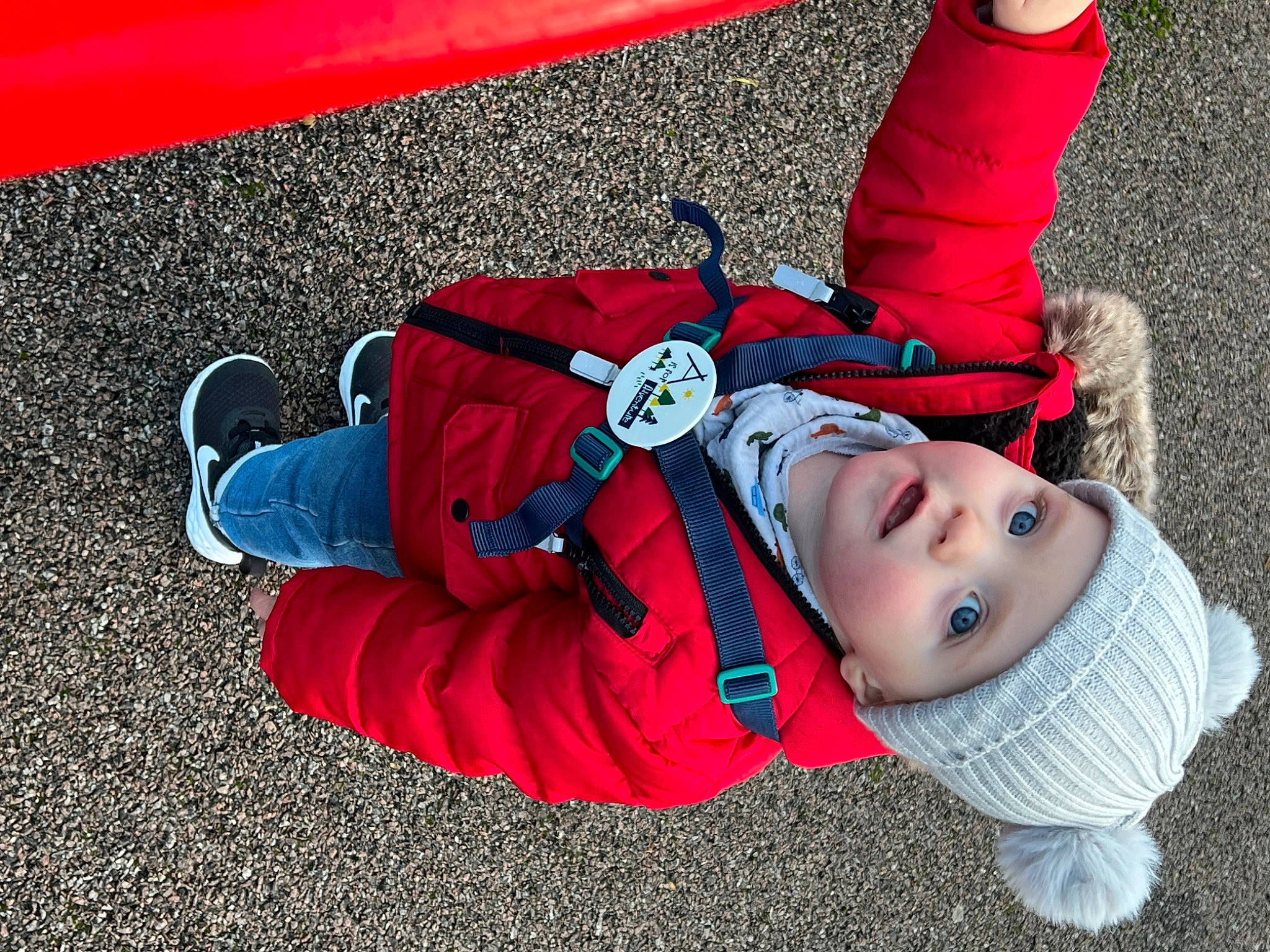 Archie is registered to the contest to win money with this photo: baby, carmine, child, cool, electric_blue, fun, grass, happy, headwear, leg, leisure, people, person, plant, play, recreation, red, sitting, smile, sneakers