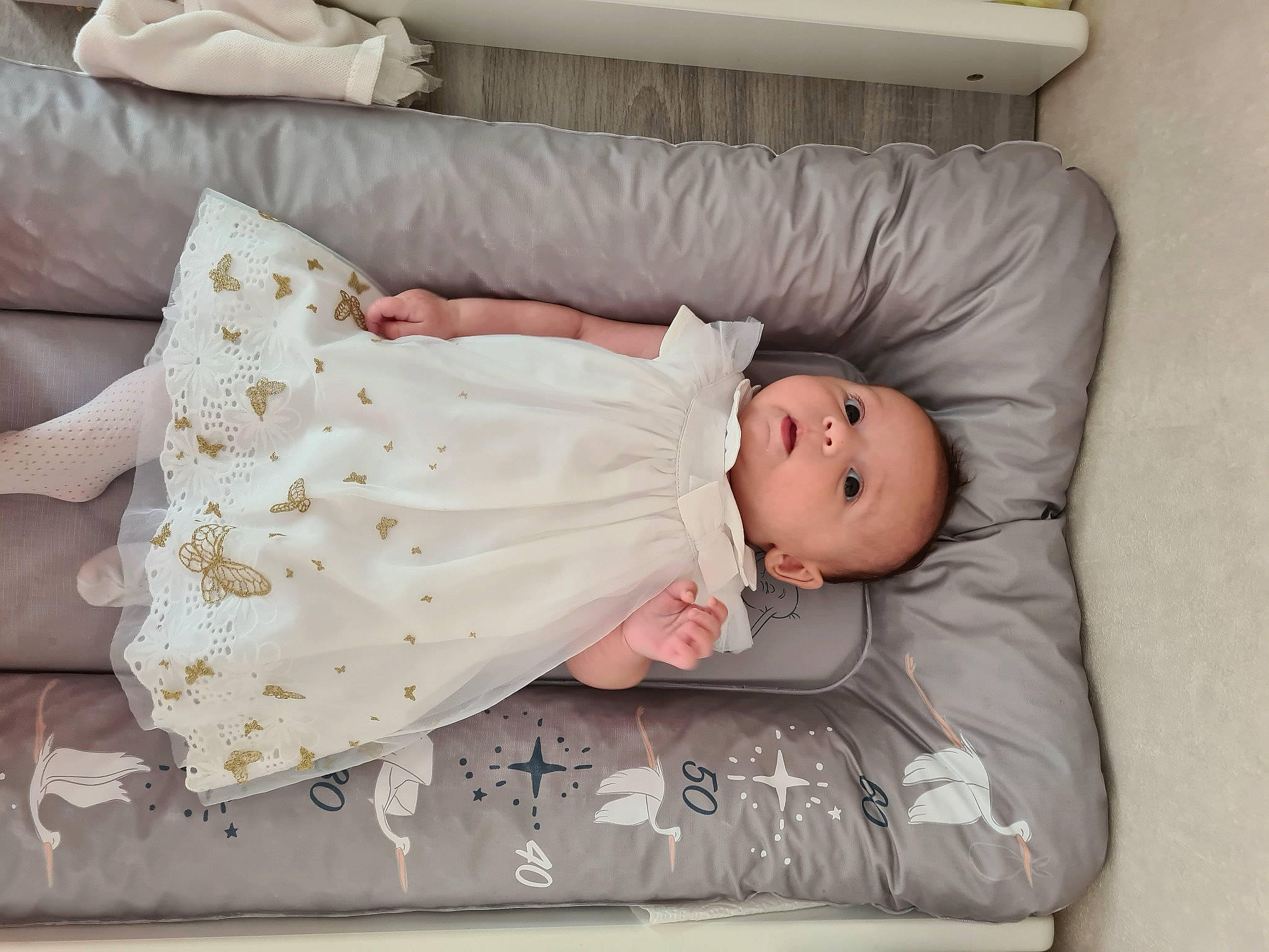 Ana participe au concours pour gagner de l'argent avec cette photo : baby, baby_products, baby_safety, baby_sleeping, baby_toddler_clothing, bed, bedding, child, comfort, dress, embellishment, flooring, linens, mammal, pattern, person, room, sitting, sleeve, toddler