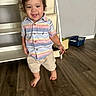 Adrian is registered to the contest to win money with this photo: toddler, child, barefoot, curly_hair, striped_shirt, shorts, smiling, indoor, wooden_floor, person, young_child, walking, happy, home, furniture, basket, playful, cute, portrait, casual_clothing