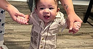 Adrian is registered to the contest to win money with this photo: adult, baby, child, clothing, floor, flooring, footwear, hands, happy, helping, home, indoor, person, shirt, shorts, smile, tattoo, toddler, walking, wooden_floor