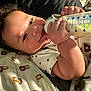 Adrian is registered to the contest to win money with this photo: baby, blanket, bottle, cheeks, child, clothing, cozy, cute, face, feeding, hand, indoor, infant, lion_print, lying_down, milk, person, sleepwear, smile, soft