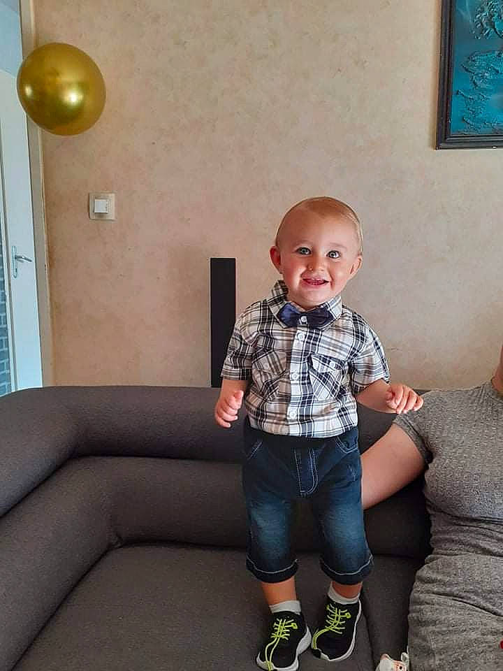 Ethan a rejoint le concours — aidez-le/la à gagner de superbes lots ! baby_toddler_clothing, blue, comfort, couch, eye, flash_photography, flooring, happy, joint, joy, knee, leg, person, picture_frame, skin, sleeve, smile, standing, toddler, wall