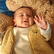 Jud a rejoint le concours — aidez-le/la à gagner de superbes lots ! baby, blanket, child, close_up, clothing, cozy, cuddly, cute, fluffy_vest, hand, happy, indoors, infant, portrait, sleepy, smiling, soft_texture, teddy_bear_patch, warm_colors, waving_hand