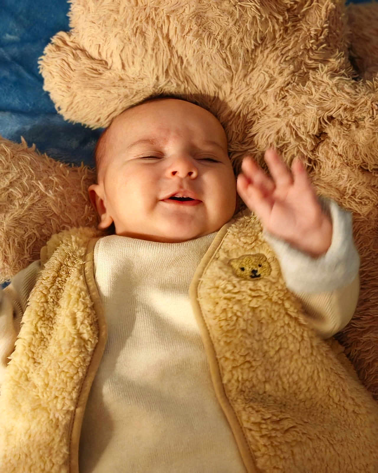 Jud a rejoint le concours — aidez-le/la à gagner de superbes lots ! baby, blanket, child, close_up, clothing, cozy, cuddly, cute, fluffy_vest, hand, happy, indoors, infant, portrait, sleepy, smiling, soft_texture, teddy_bear_patch, warm_colors, waving_hand