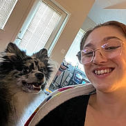 Theo joined the competition — help win amazing prizes! dog, woman, person, smiling, glasses, portrait, selfie, indoors, home, fluffy, long_hair, black_and_white, pet, companion, happy, teeth, window, blinds, furniture, photography