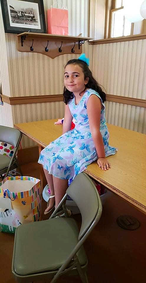 Ashton is registered to the contest to win money with this photo: box, electric_blue, event, face, fashion_design, flooring, fun, happy, human_leg, joy, knee, leisure, pattern, person, play, recreation, room, sitting, sock, table