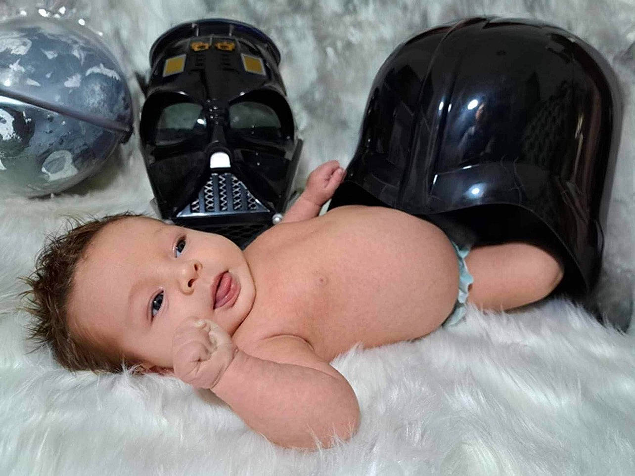 Saint is registered to the contest to win money with this photo: arm, baby, black, black_hair, chest, comfort, eye, eyewear, facial_expression, finger, flash_photography, fun, happy, hat, head, human_body, mouth, organ, person, skin