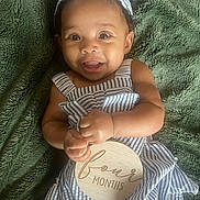 Harper is registered to the contest to win money with this photo: baby, child, closeup, cute, eyes, fabric, four_months, hands, happy, headband, infant, lying_down, mouth, plush_blanket, portrait, skin, smiling, striped_clothing, texture, wooden_sign