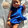 baby, infant, child, blue_dress, pink_bows, curly_hair, smiling, lying_down, blanket, wooden_plaque, three_months, natural_light, cute, portrait, soft, skin, adorable, happy, indoor, closeup