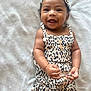 baby, child, smiling, happy, leopard_print, headband, clothing, infant, cute, portrait, skin, hand, face, lying_down, blanket, button, fashion, young, person, indoors