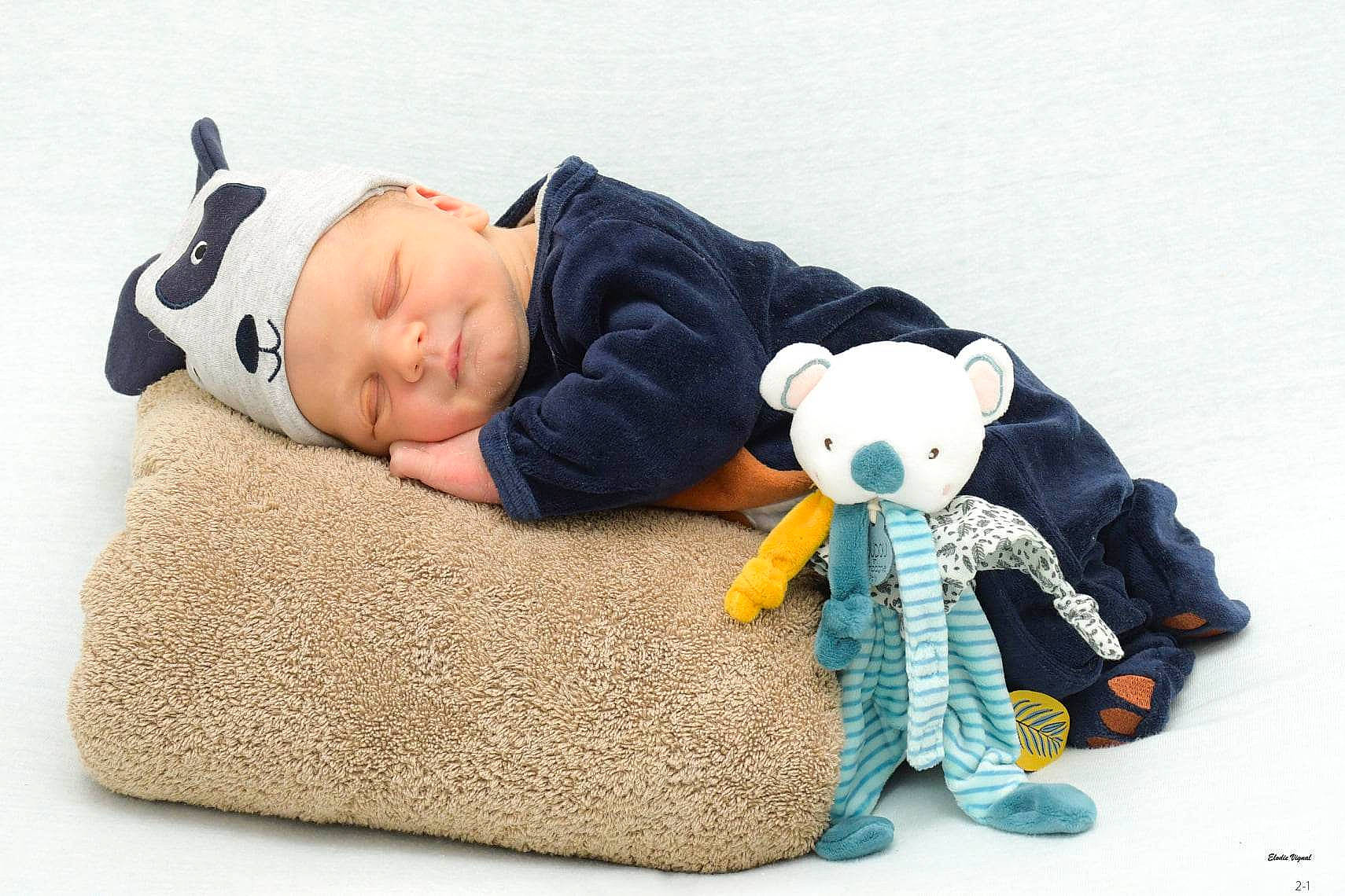 Nolan participe au concours pour gagner de l'argent avec cette photo : baby, baby_products, baby_sleeping, baby_toddler_clothing, baby_toys, child, collectable, comfort, couch, font, happy, headwear, linens, person, plush, room, sitting, sleeve, stuffed_toy, teddy_bear