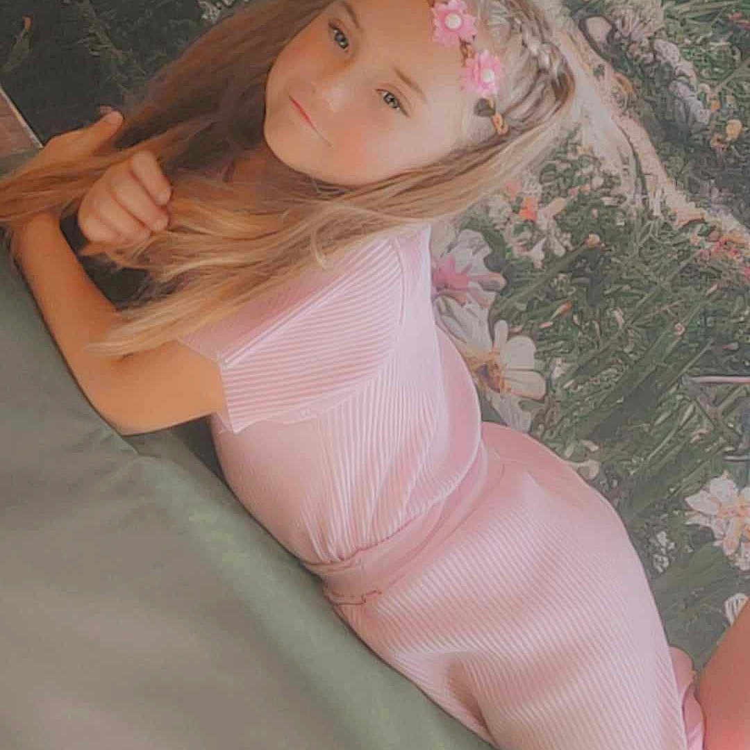 Mya participe au concours pour gagner de l'argent avec cette photo : beauty, brown_hair, child, dress, flash_photography, grass, happy, human_leg, lip, peach, people_in_nature, pink, plant, sitting, skin, smile, thigh, toddler, tree, wood