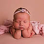 Ruby is registered to the contest to win money with this photo: baby, sleeping, headband, pink, newborn, infant, hands, feet, soft_fabric, portrait, cute, peaceful, child, closeup, studio, adorable, resting, skin, flower, tender