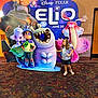 Megan is registered to the contest to win money with this photo: child, girl, movie_promo, cardboard_cutout, pixar, disney, elio, smiling, posing, cinema_lobby, colorful, cartoon_character, standee, poster, indoor, carpet, sandals, skirt, advertisement, family_outing